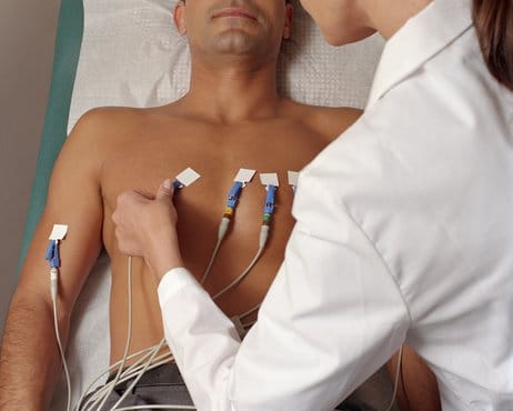 Female doctor giving male patient EKG, mid section, elevated view